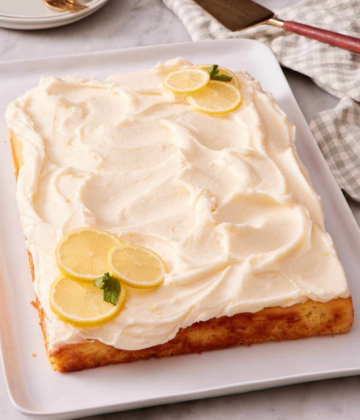 A lemon sheet cake decorated with lemon slices.