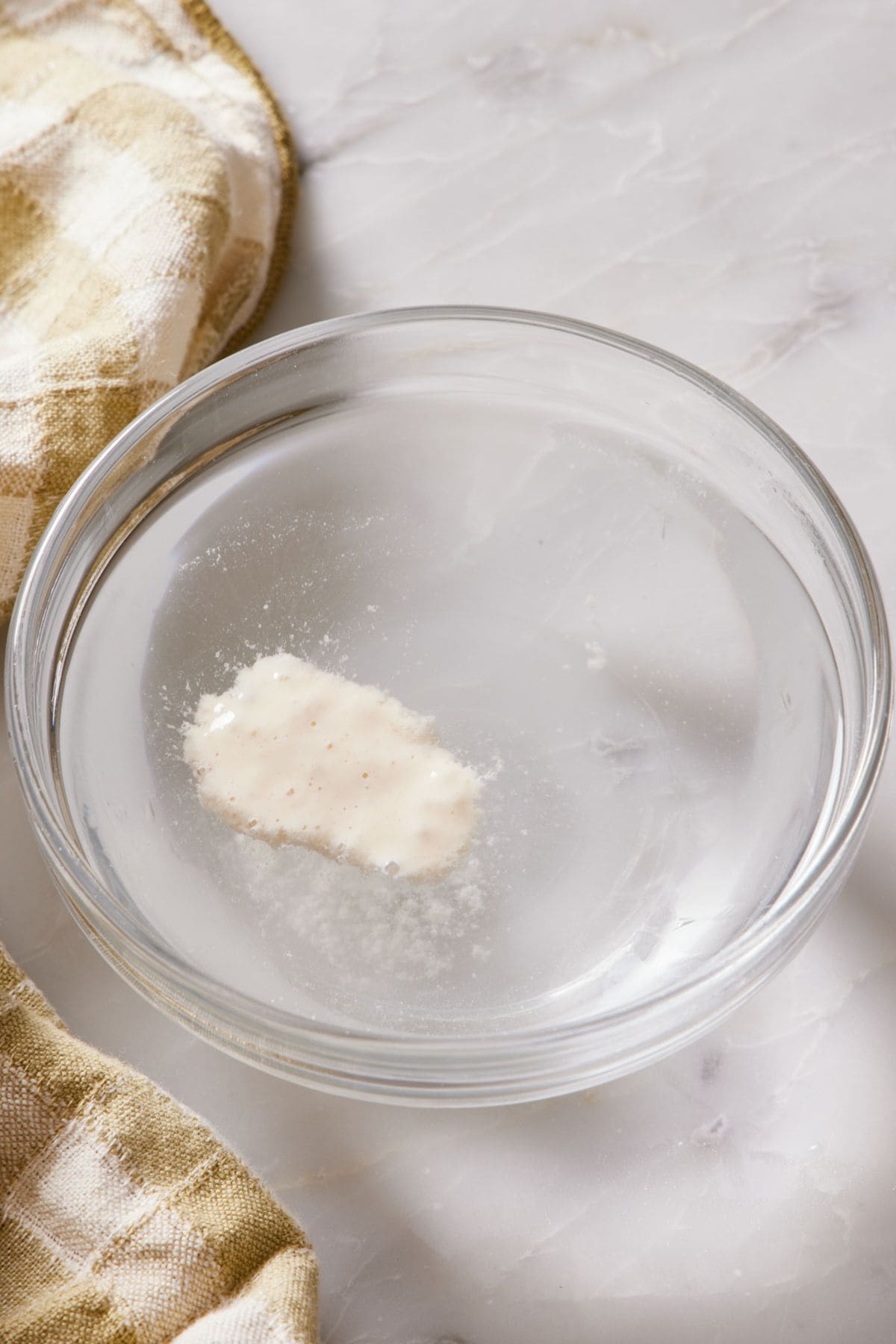 A small spoonful of sourdough starter floating in water to determine whether or not it is active.