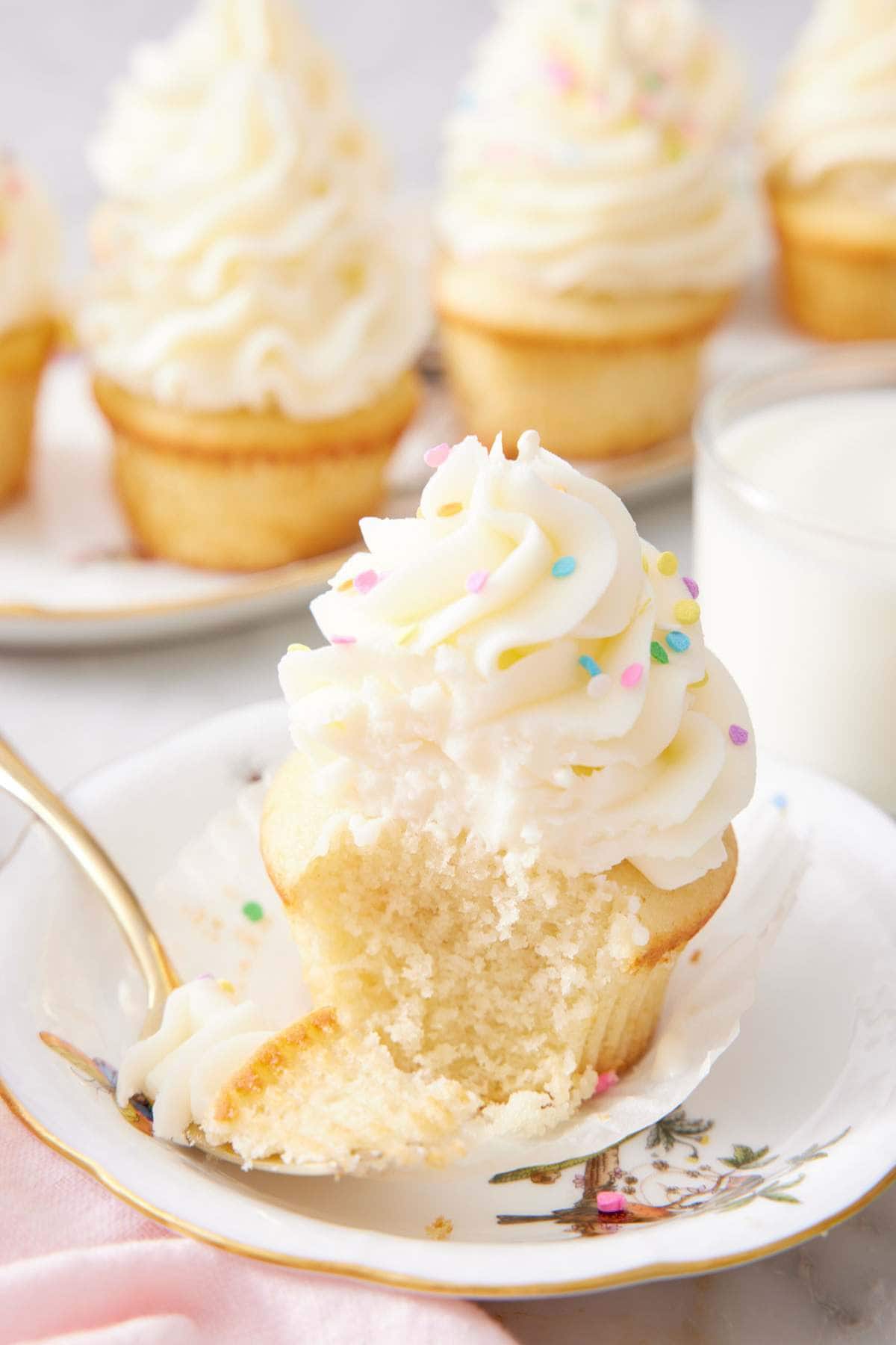A vanilla cupcake with a forkful removed.