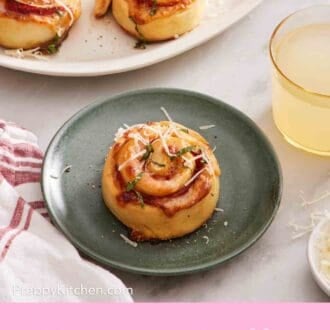 Pinterest graphic showing a pizza roll sprinkled with cheese on a plate, with a drink and more pizza rolls around it.