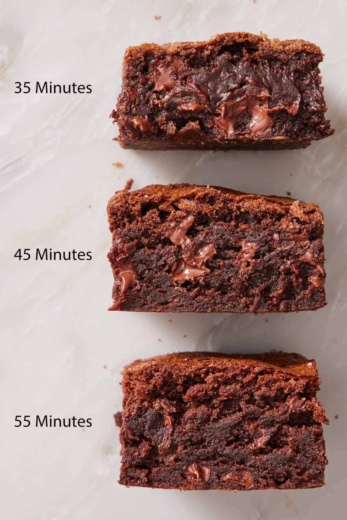 Three brownies laid on their side in a row to show their doneness at 35 minutes, 45 minutes, and 55 minutes.