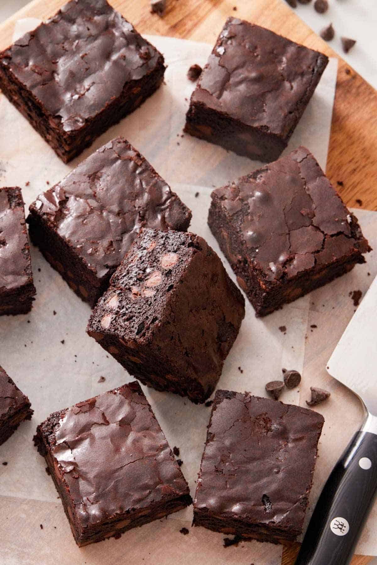 Several homemade brownies on parchment paper.