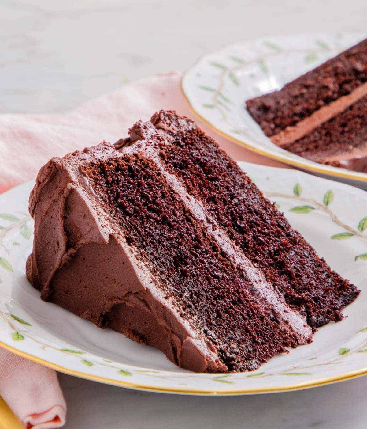 Close-up of a slice of devil's food cake on a patterned plate.
