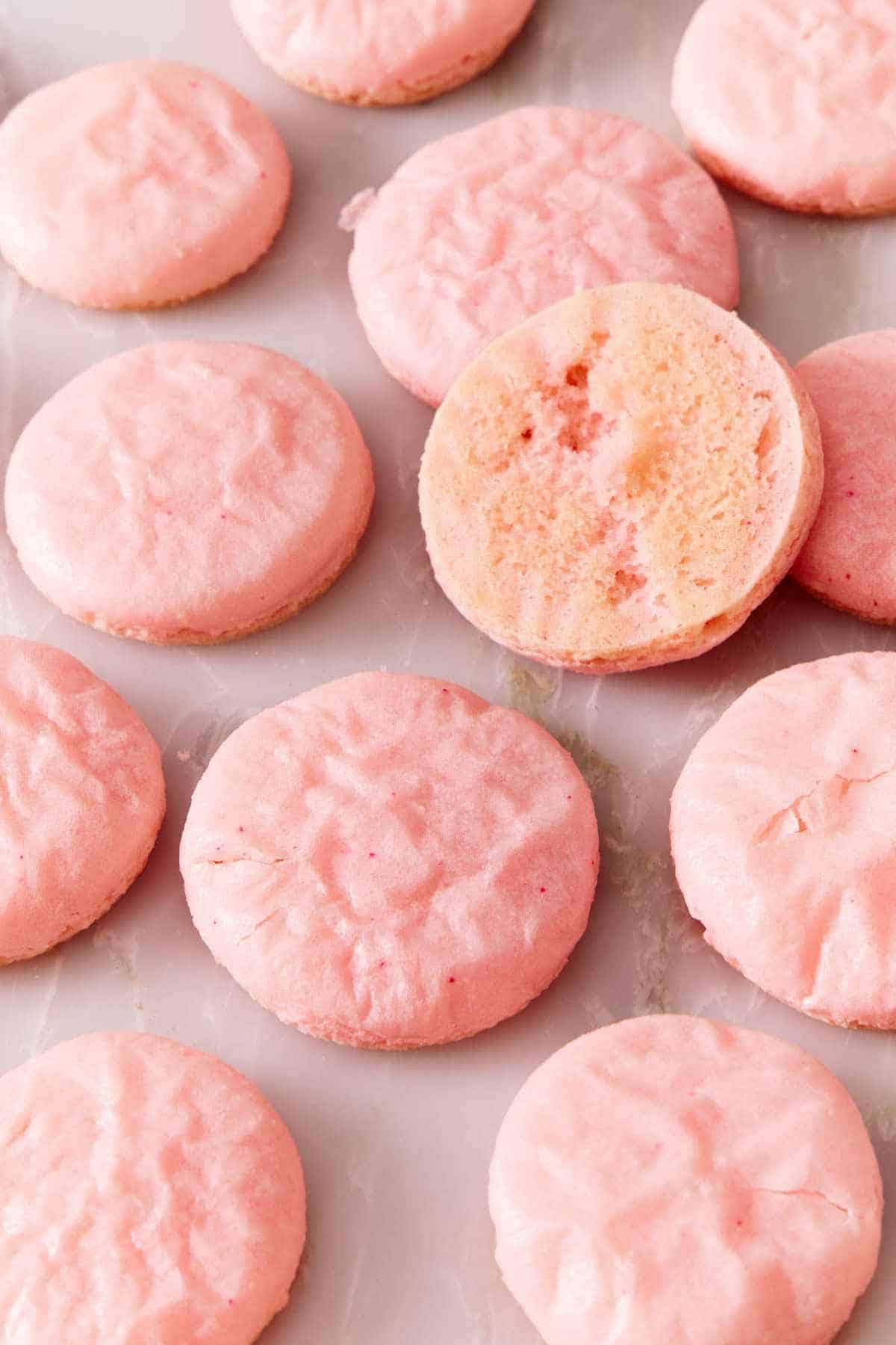 Underbaked macaron shells, one flipped over to show the underside.