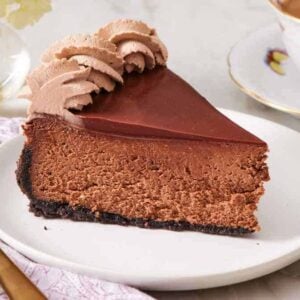 Close-up of a slice of chocolate cheesecake on a small plate.