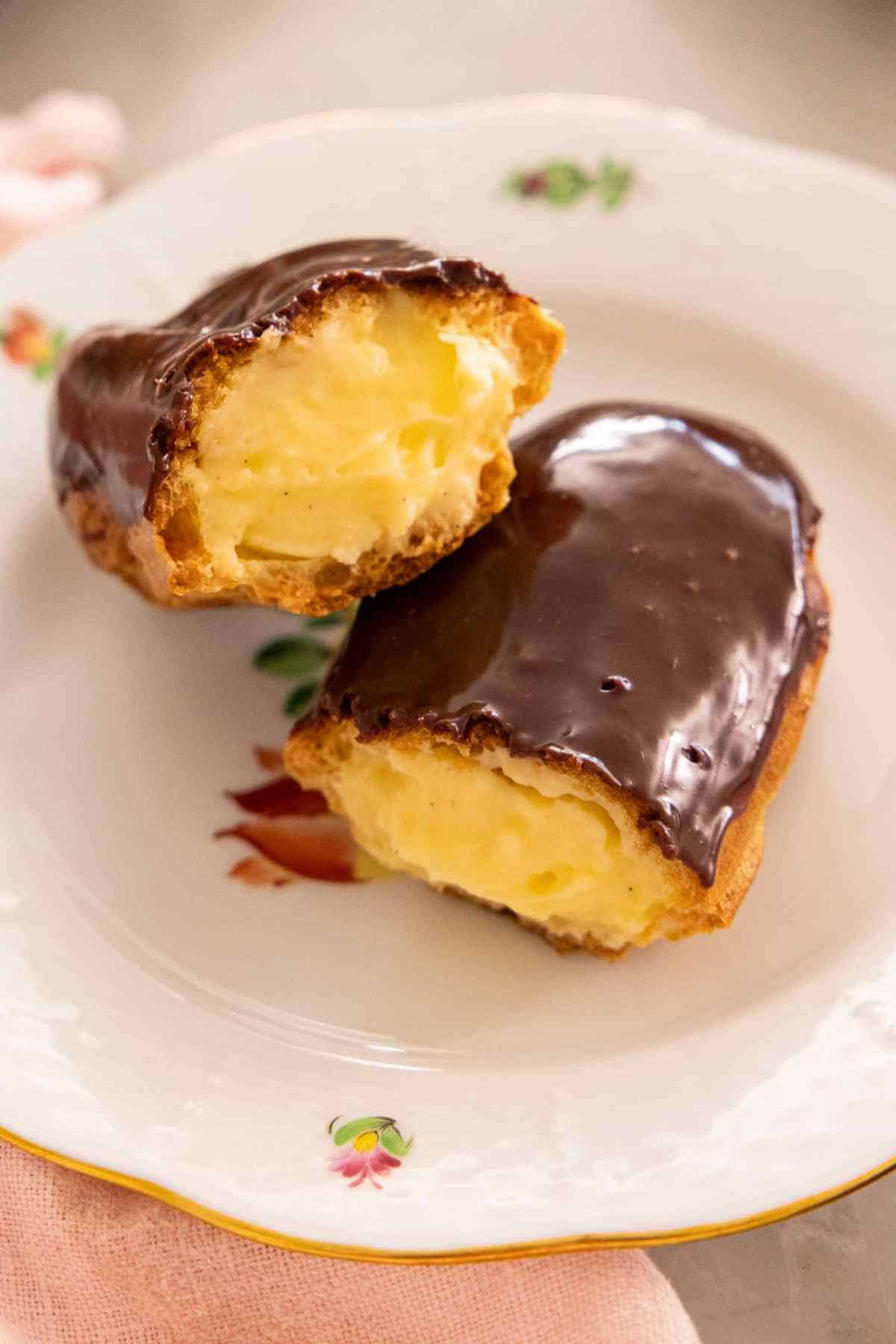 An eclair, halved, on a plate to show the filling.