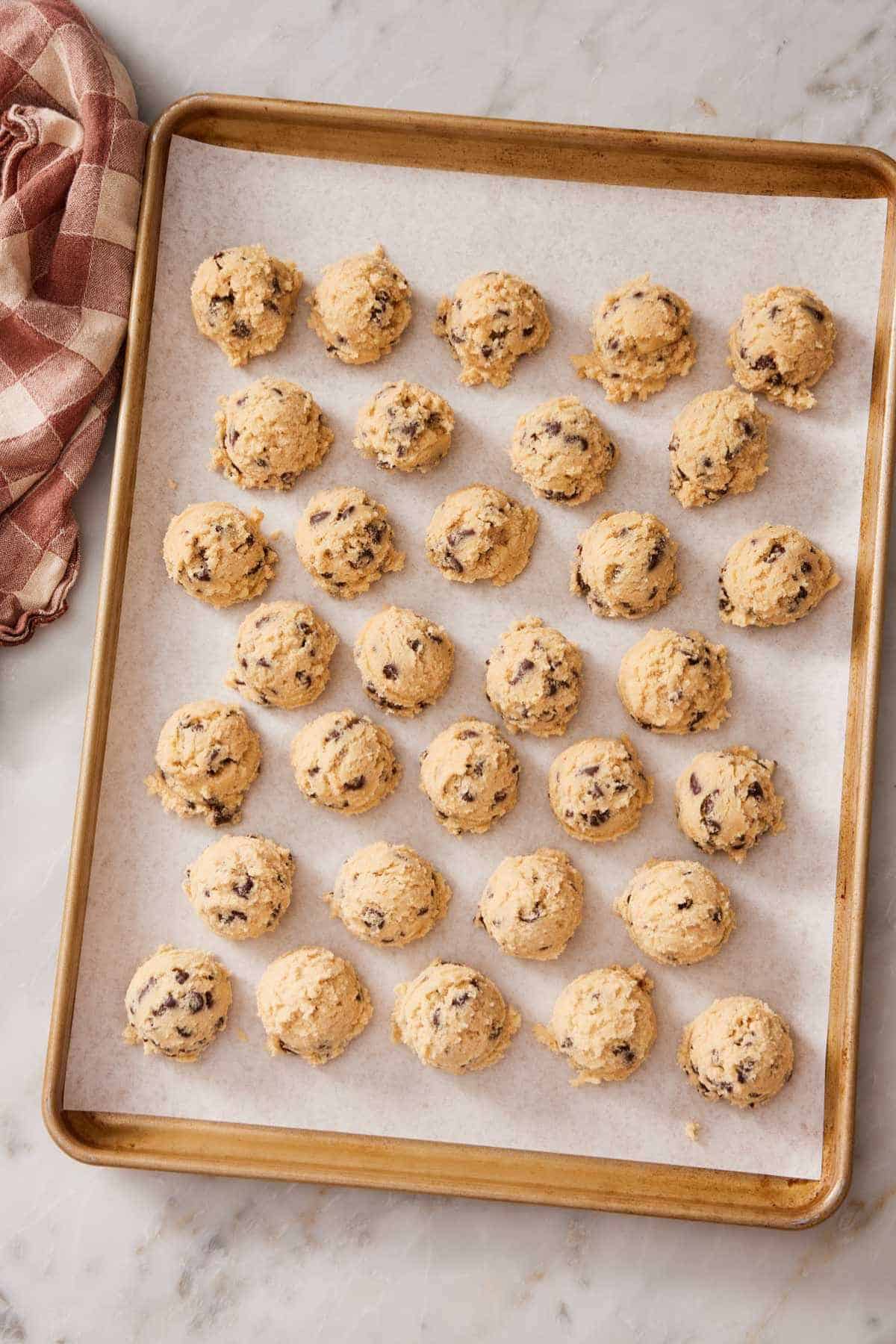 Cookie dough balls on a lined cookie sheet to show how long to chill cookie dough.