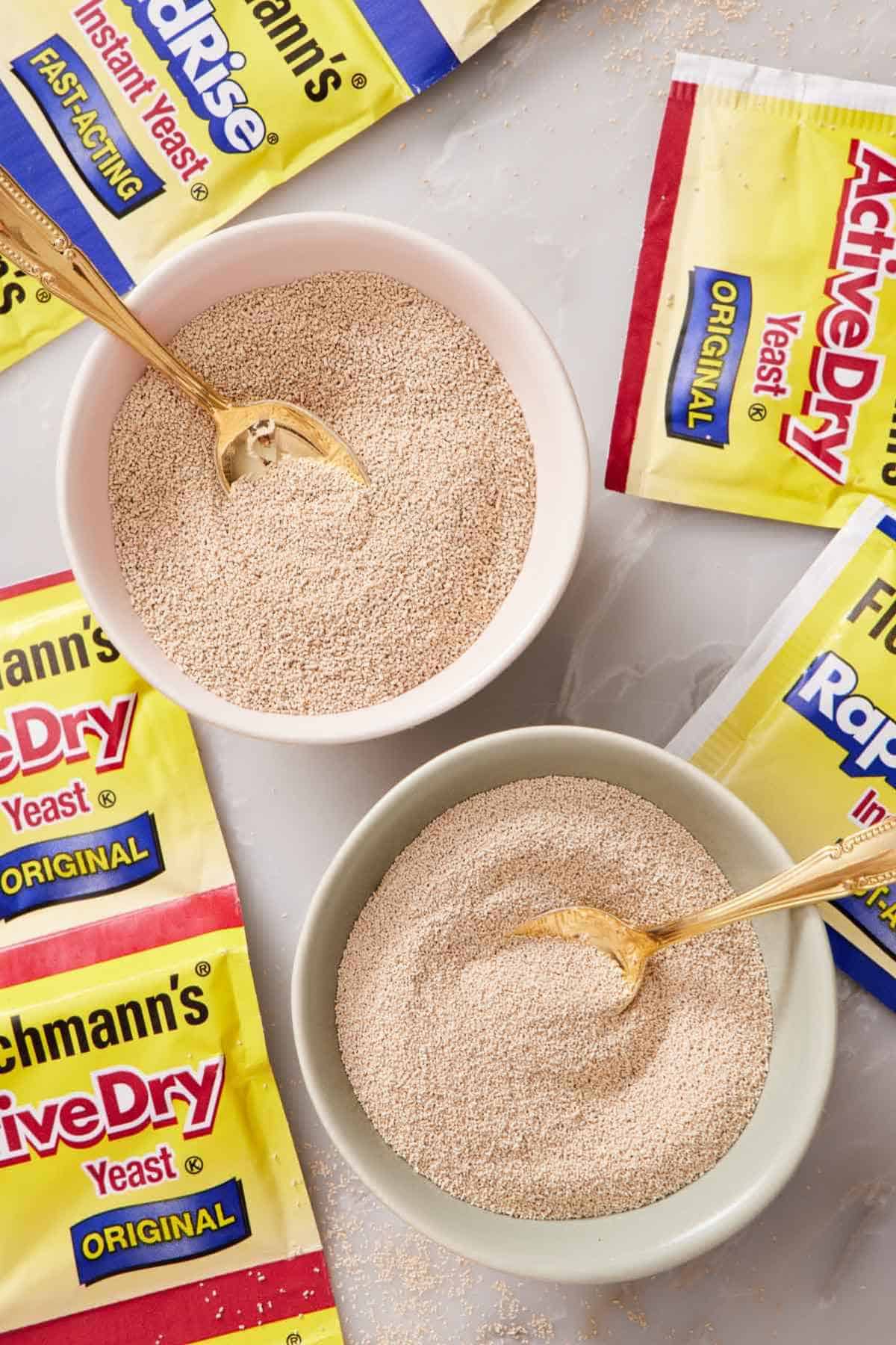 Overhead shot of yeast in a bowl surrounded by packets of yeast.