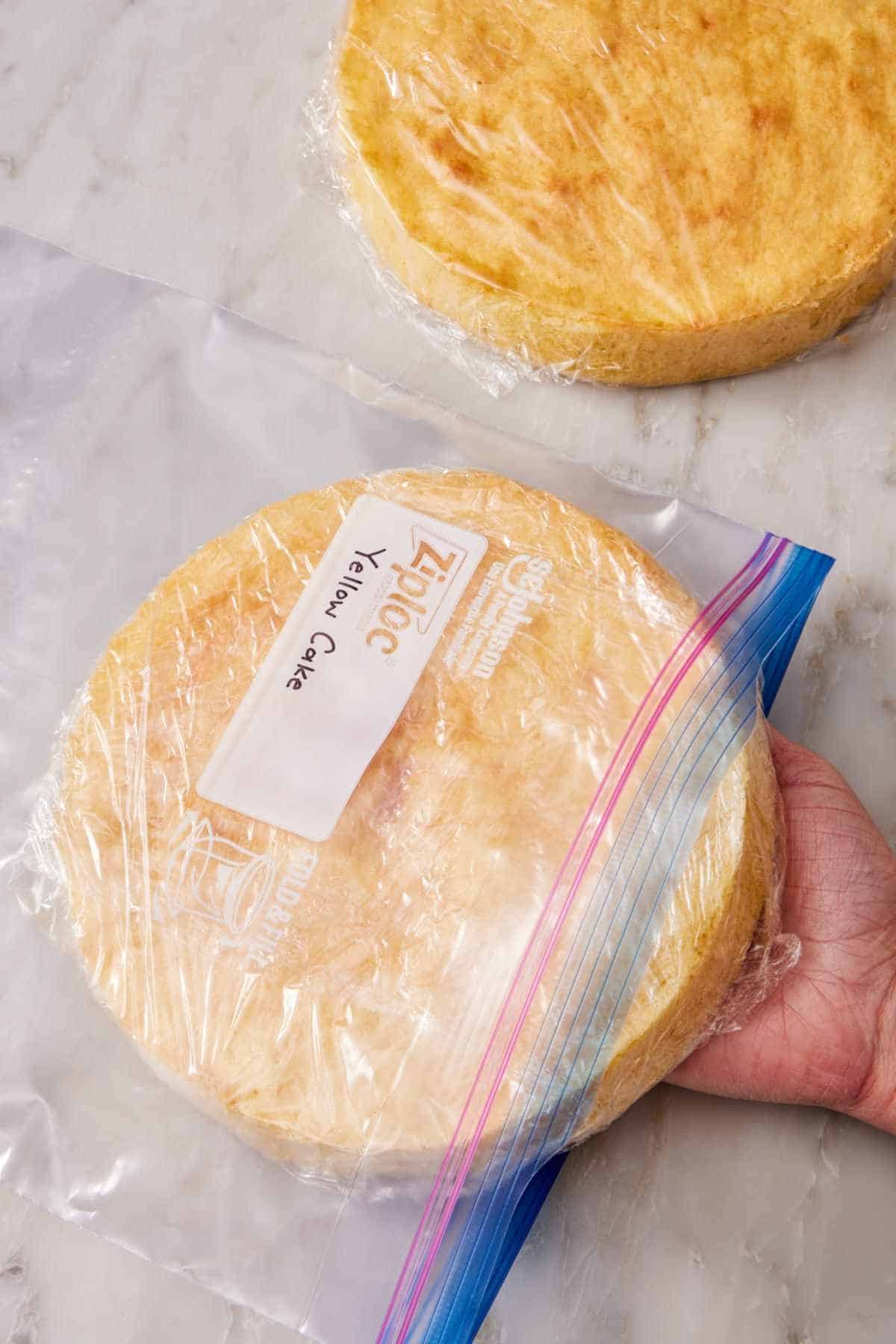 Wrapped layer of yellow cake placed into a freezer bag.