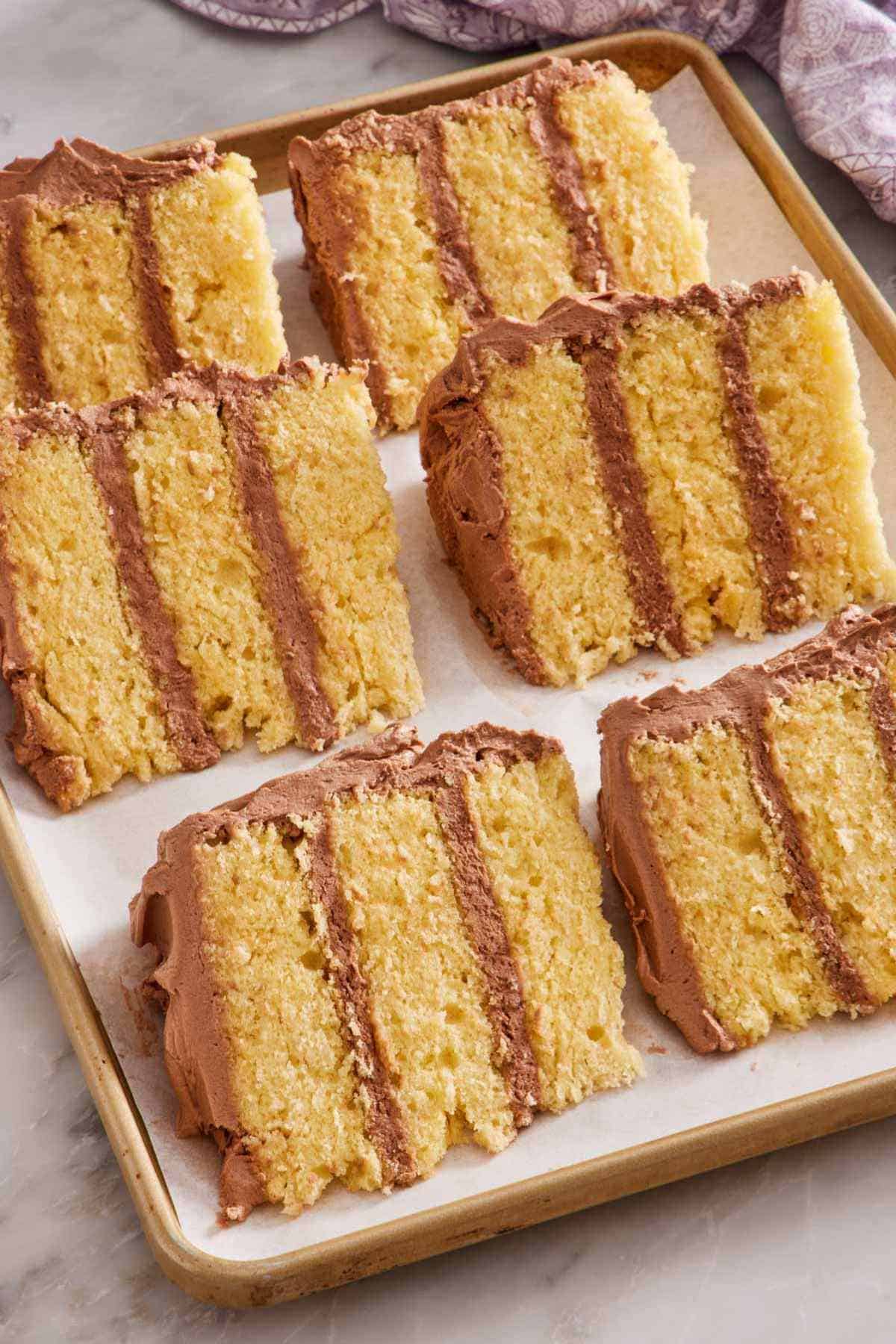 Slices of frosted layer cake on a lined baking sheet to show how to freeze cakes.