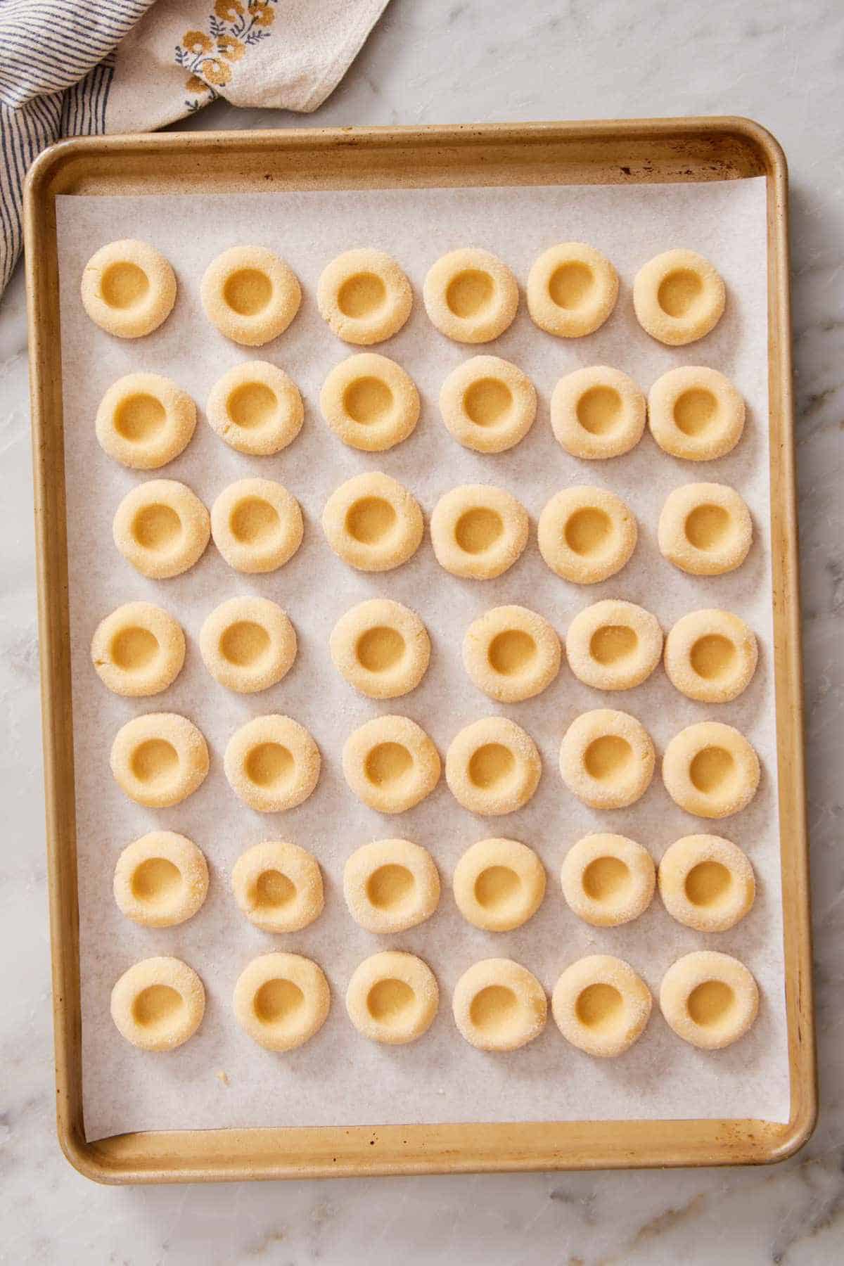 Overhead shot of shaped cookie dough on a lined baking sheet.