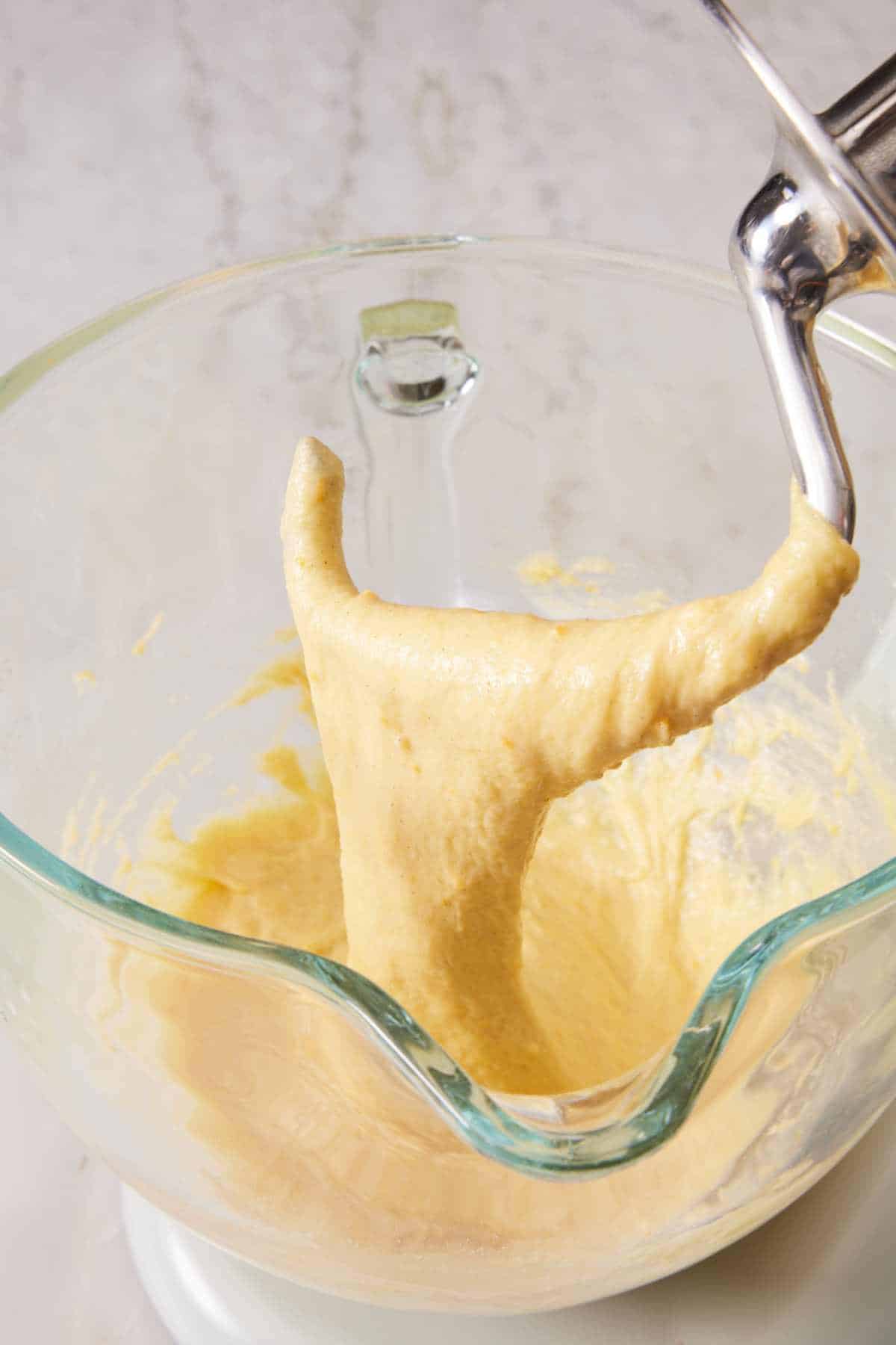 Slack dough hanging off the dough hook in the mixer.
