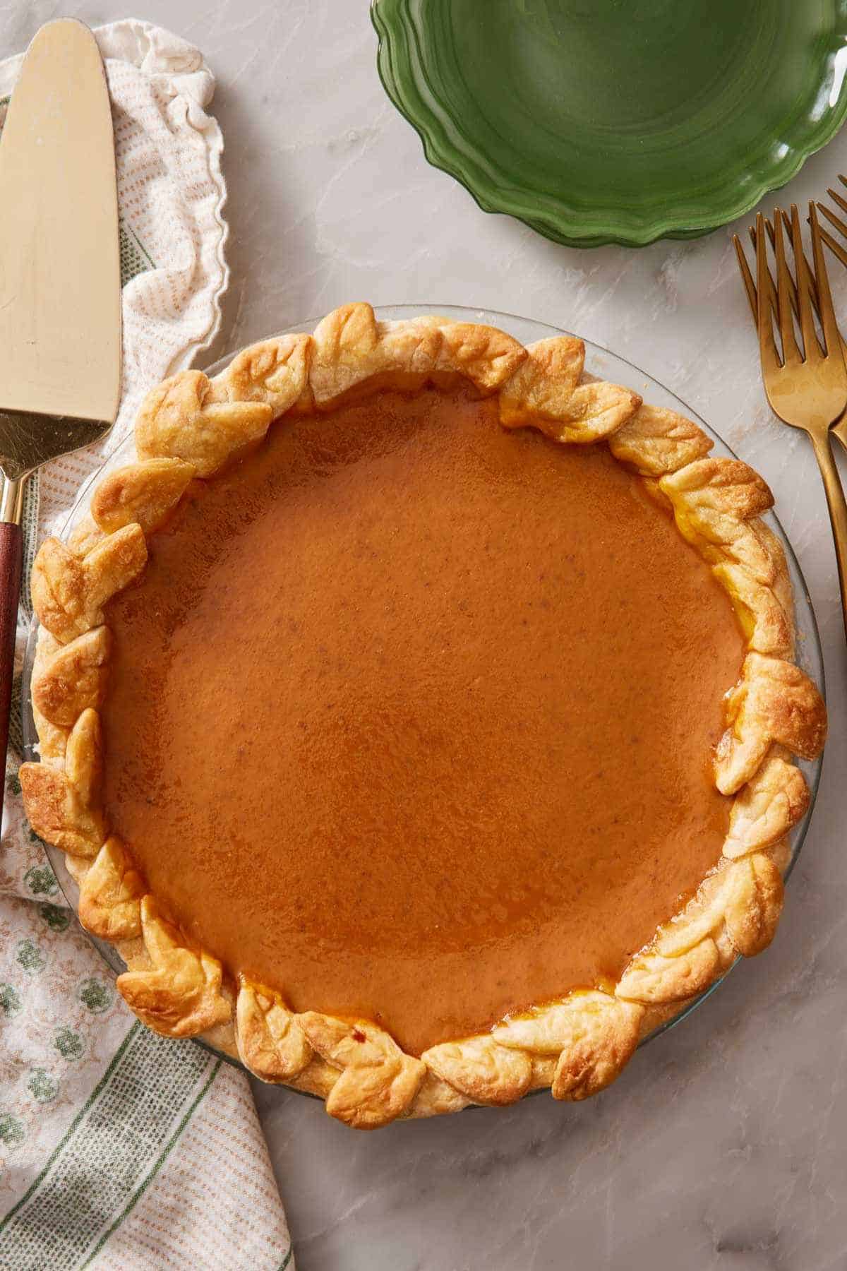 Overhead shot of a pumpkin pie with a decorative cutout edge.