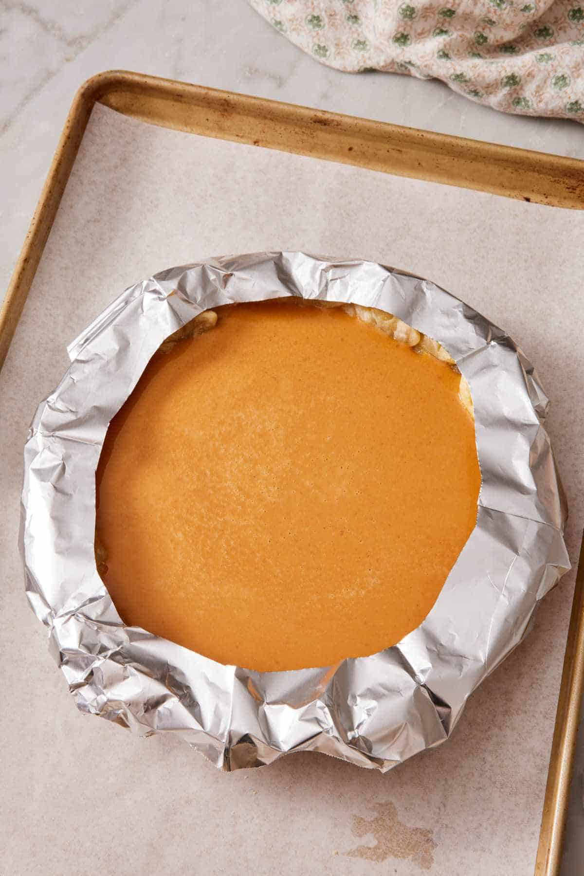 A pumpkin pie with the edges shielded using the cutout method.