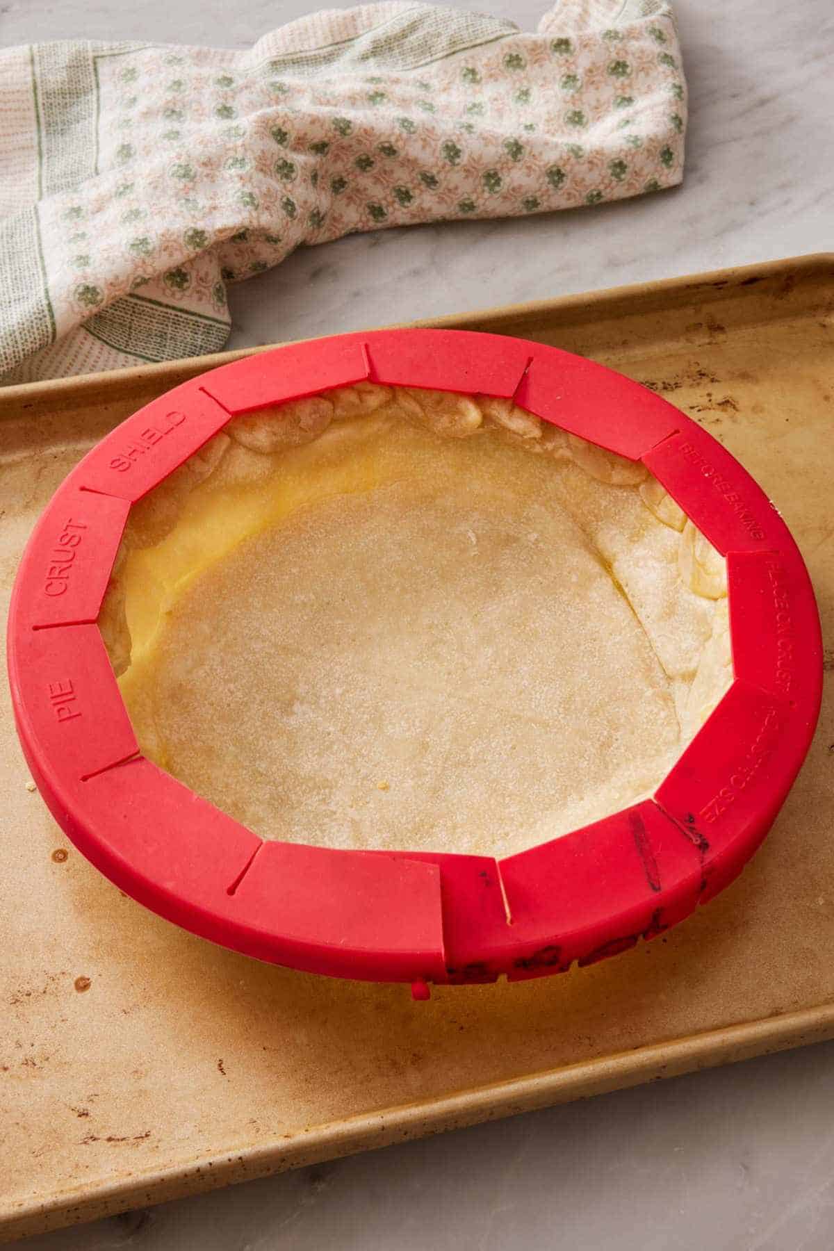 A pie crust with a store-bought silicone pie crust shield.