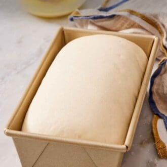 Pinterest graphic showing a loaf pan containing proofed dough.
