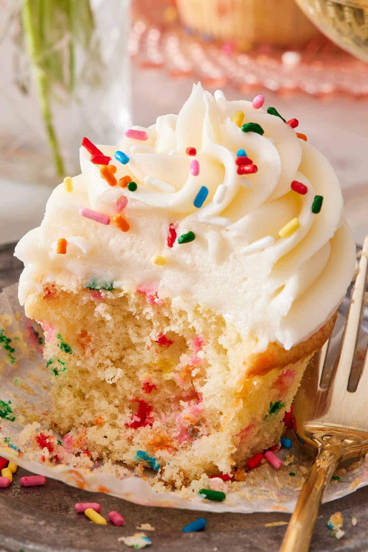 Close-up of a funfetti cupcake with a bite removed,