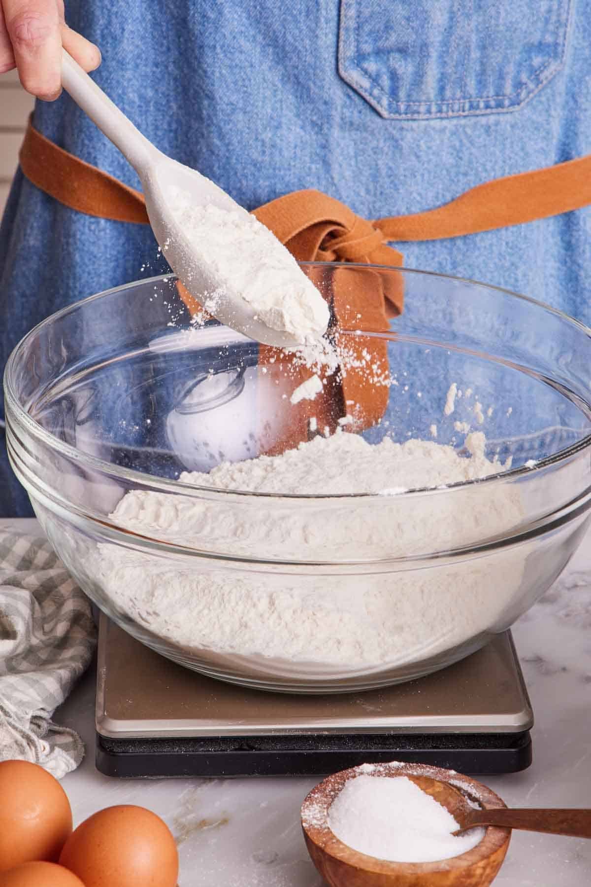 Flour added to a large bowl set on a kitchen scale.