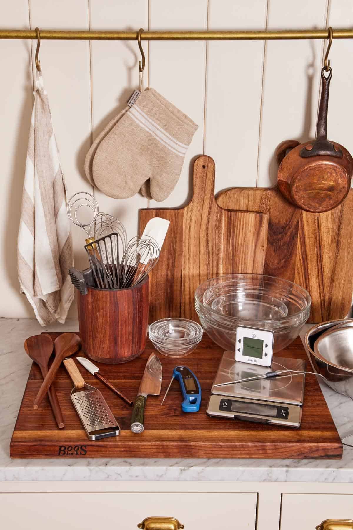 Various essential kitchen tools & utensils like oven mitts, cutting boards, spoons, and more.