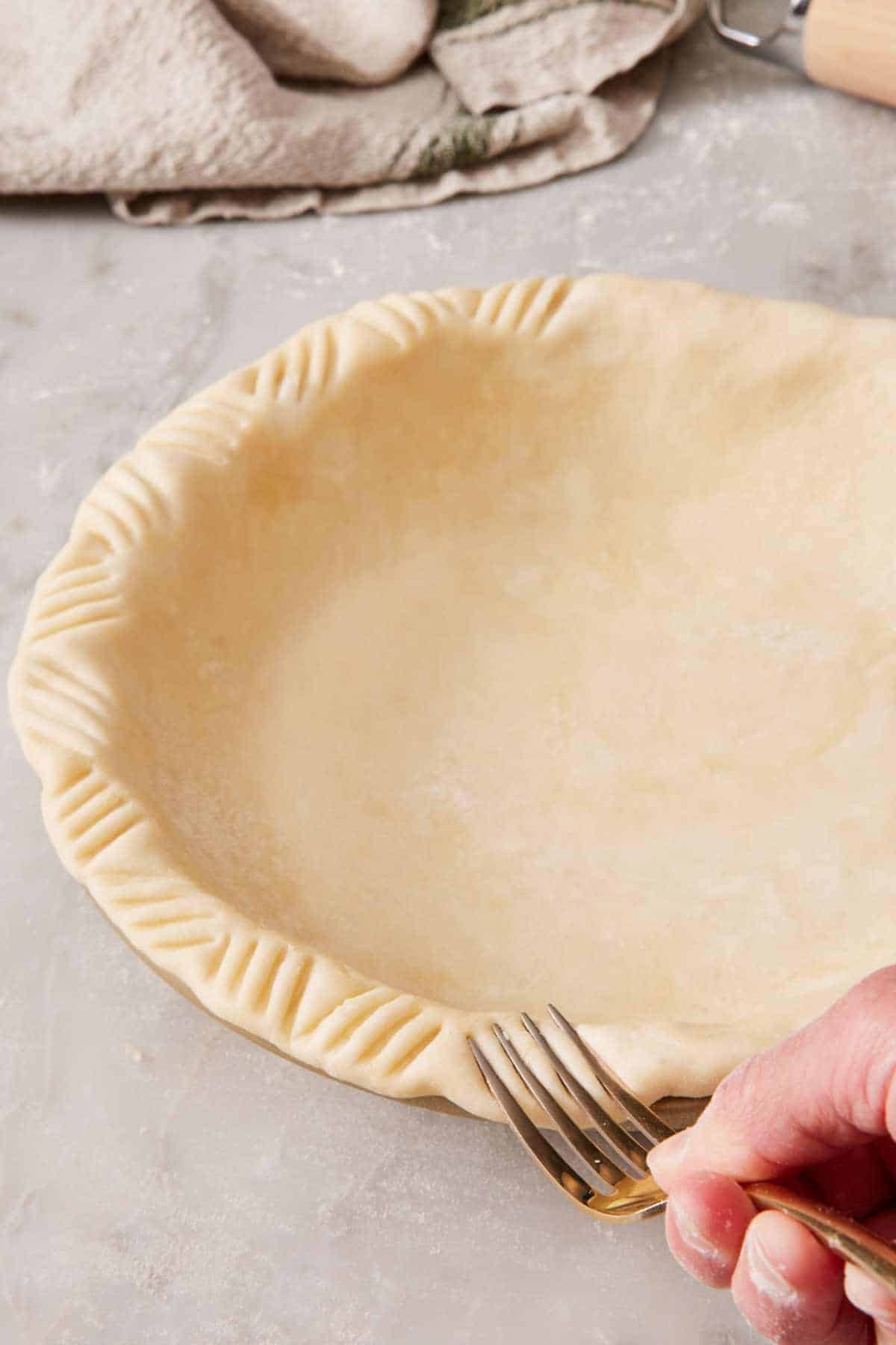 Image showing how to create a fork crimp on the edge of a pie crust.