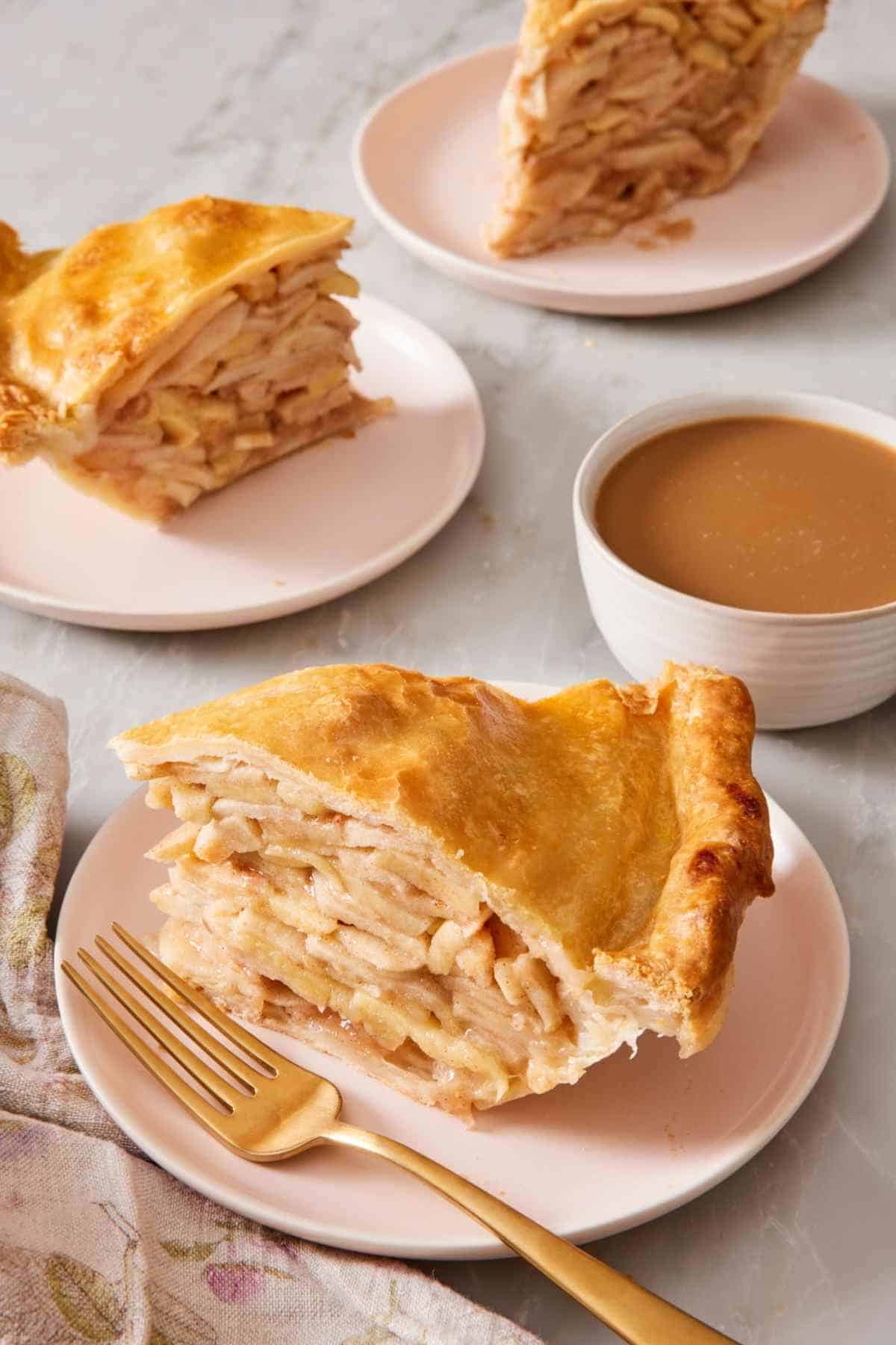 Slices of apple pie on small plates with one cup of coffee.