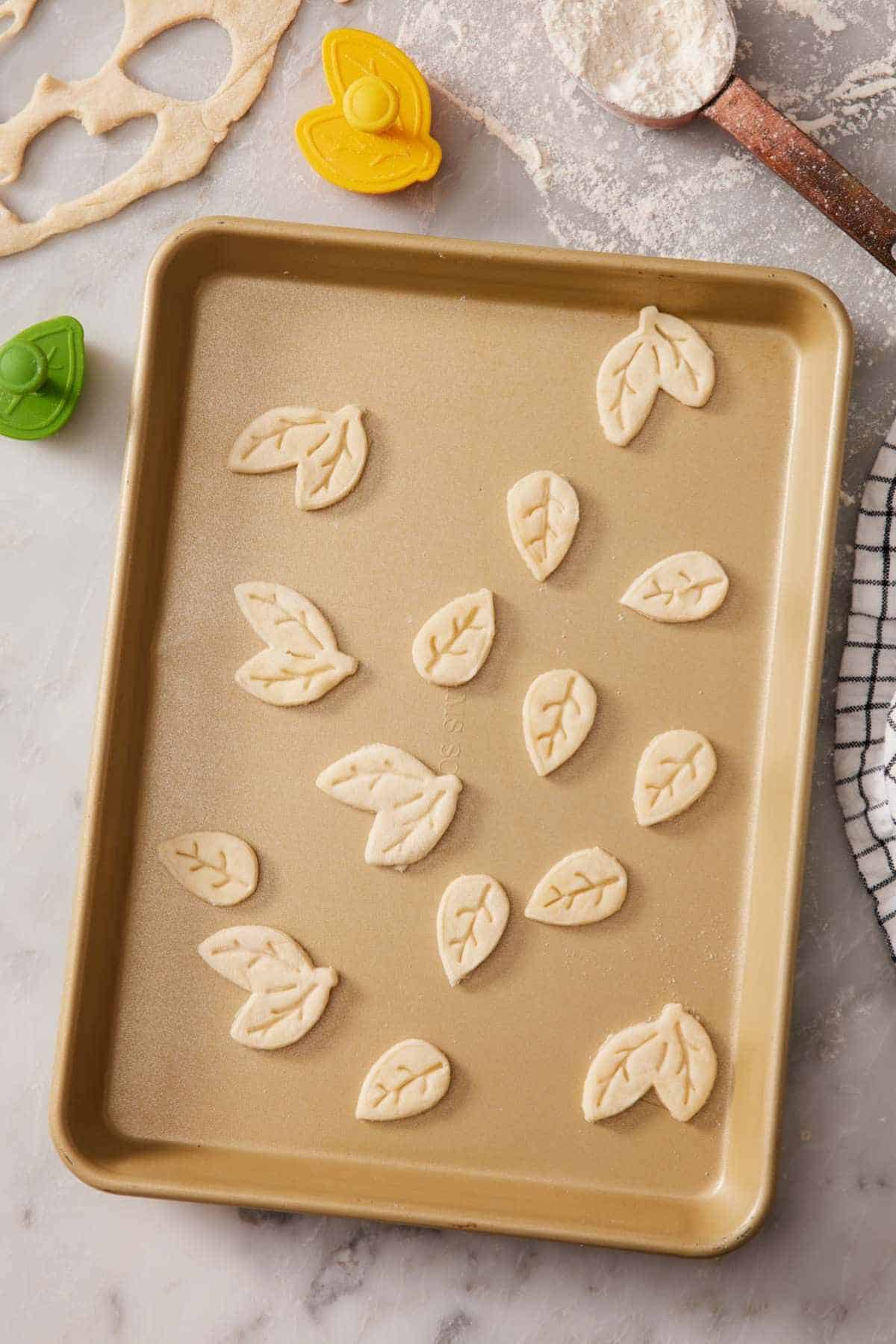 Decorative pie crust cutouts on a rimmed baking sheet.