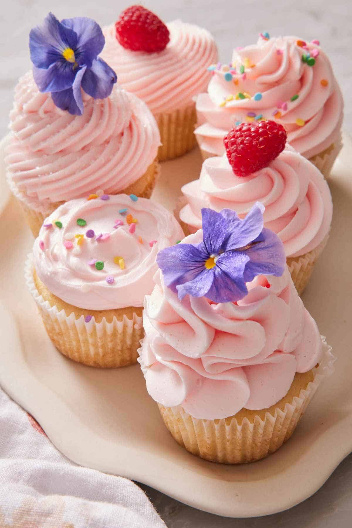 Cupcakes frosted in different methods on a platter.
