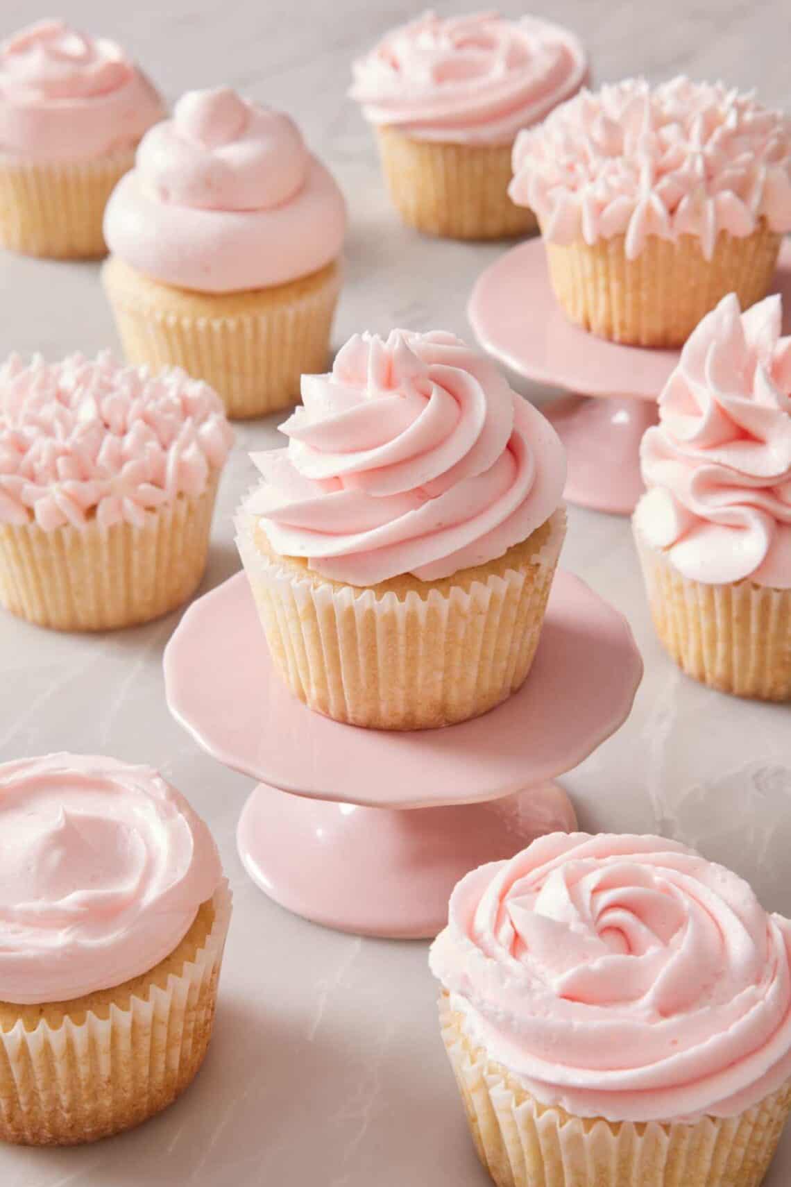 Cupcakes frosted with pink frosting in different styles.
