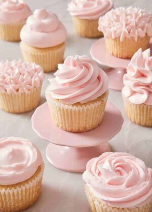 Cupcakes frosted with pink frosting in different styles.