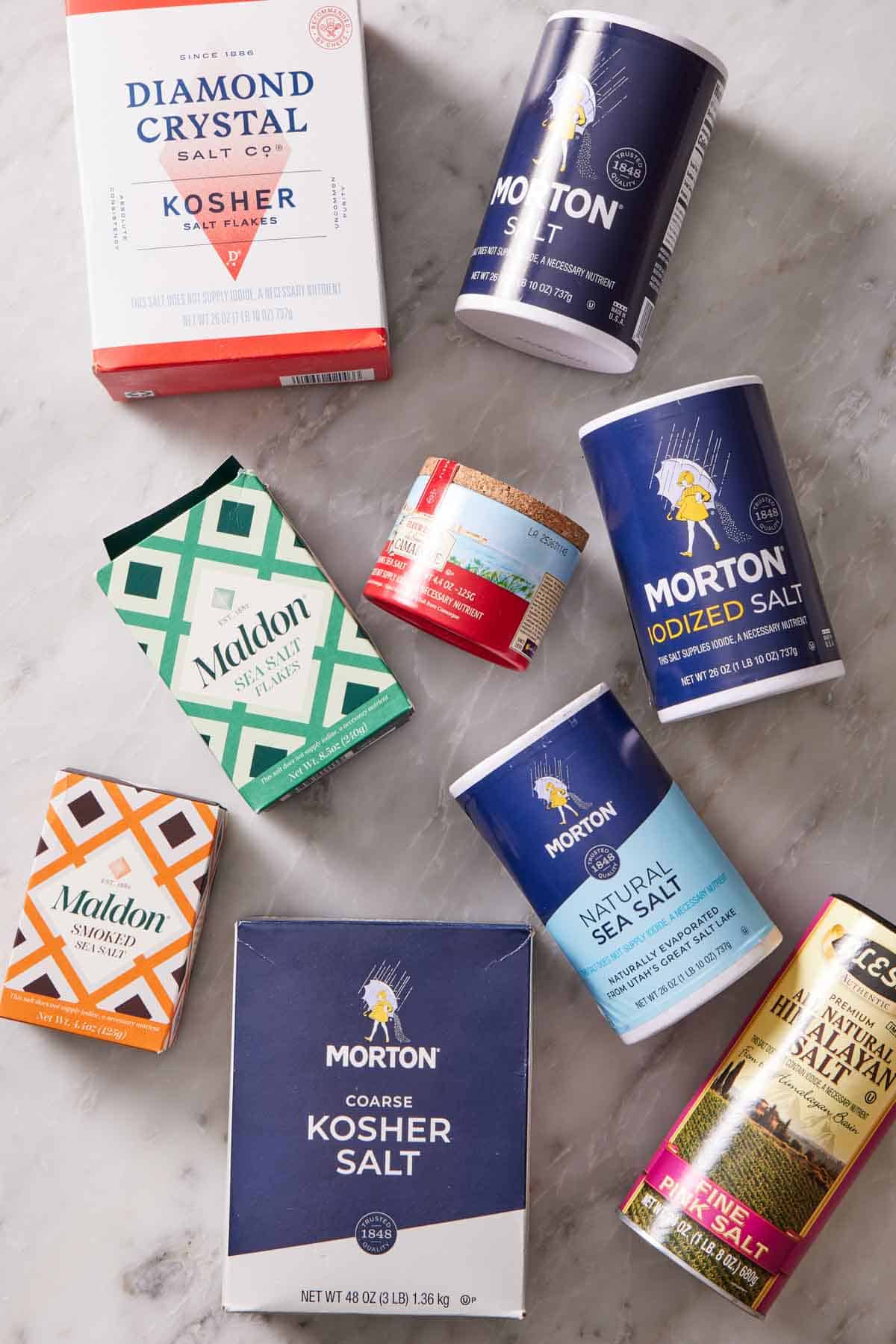 Overhead shot of different salt brands in their original packaging.