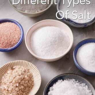 Pinterest graphic showing different types of salt in bowls on a marble counter.