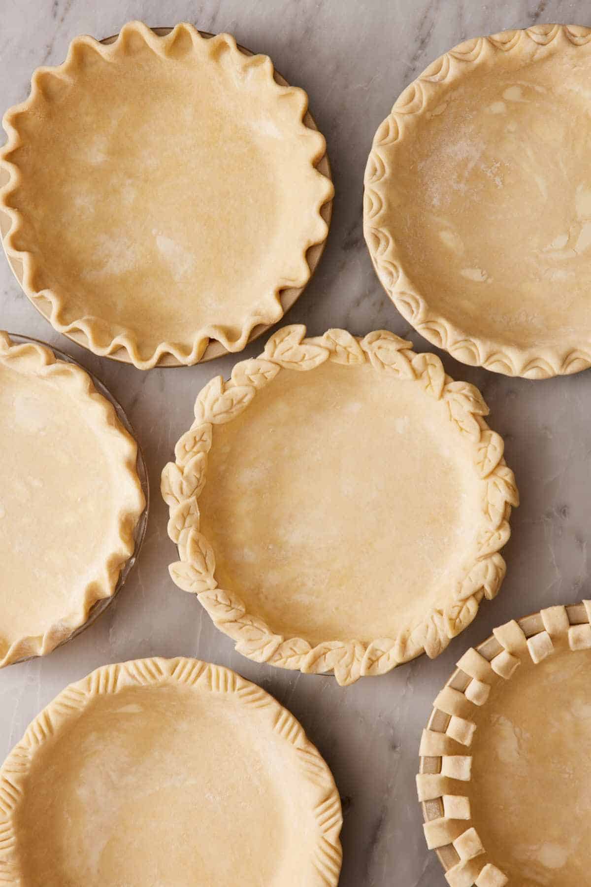 Overhead view of pie crusts with various crimp styles.