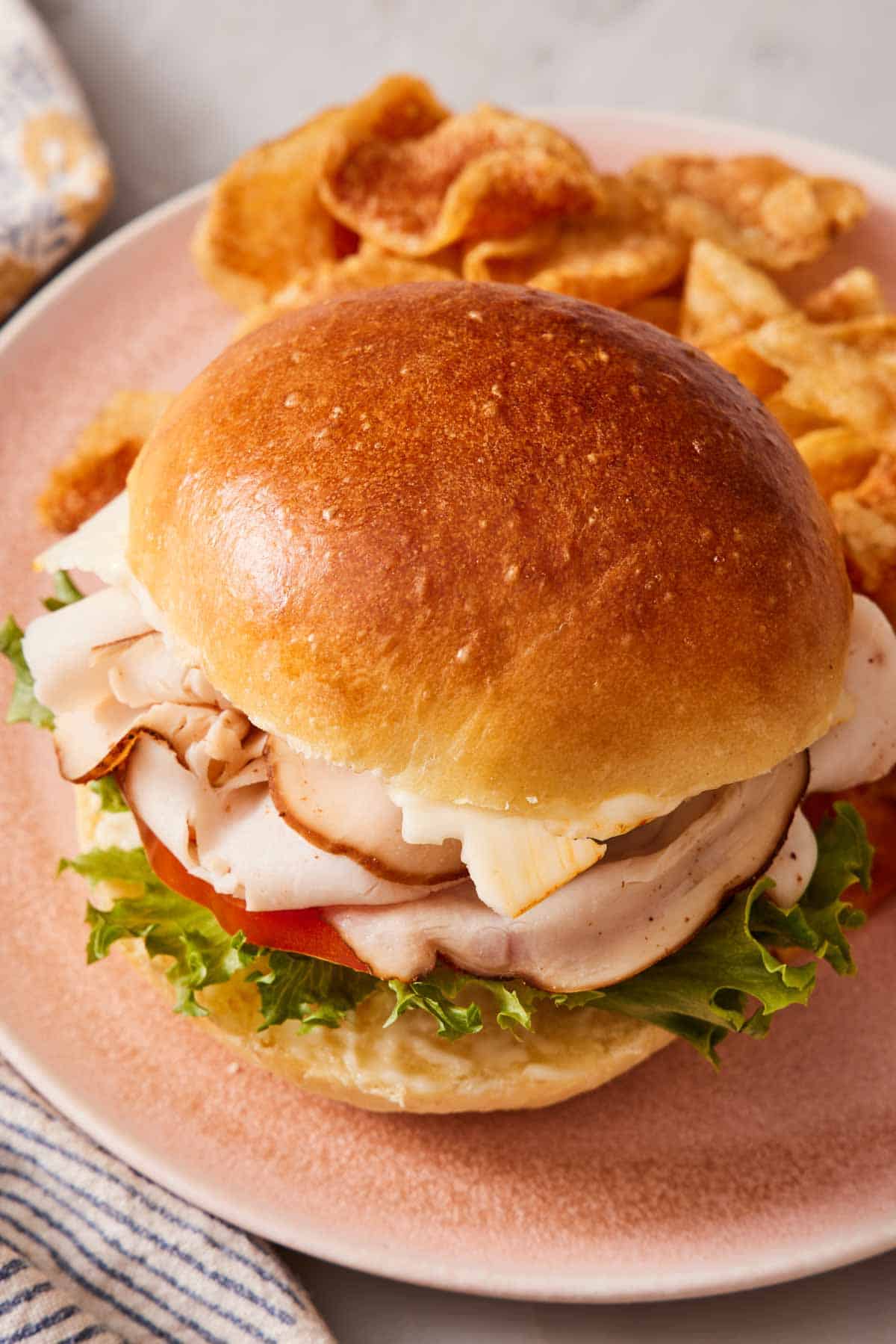 Close-up of a deli meat sandwich made with brioche buns.