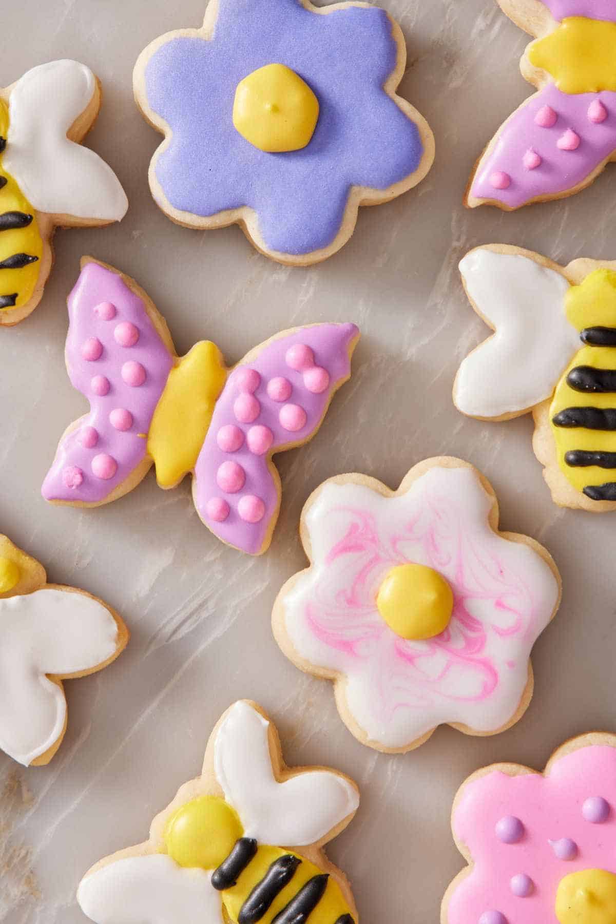 Overhead shot of decorated flower, bee, and butterfly cookies.