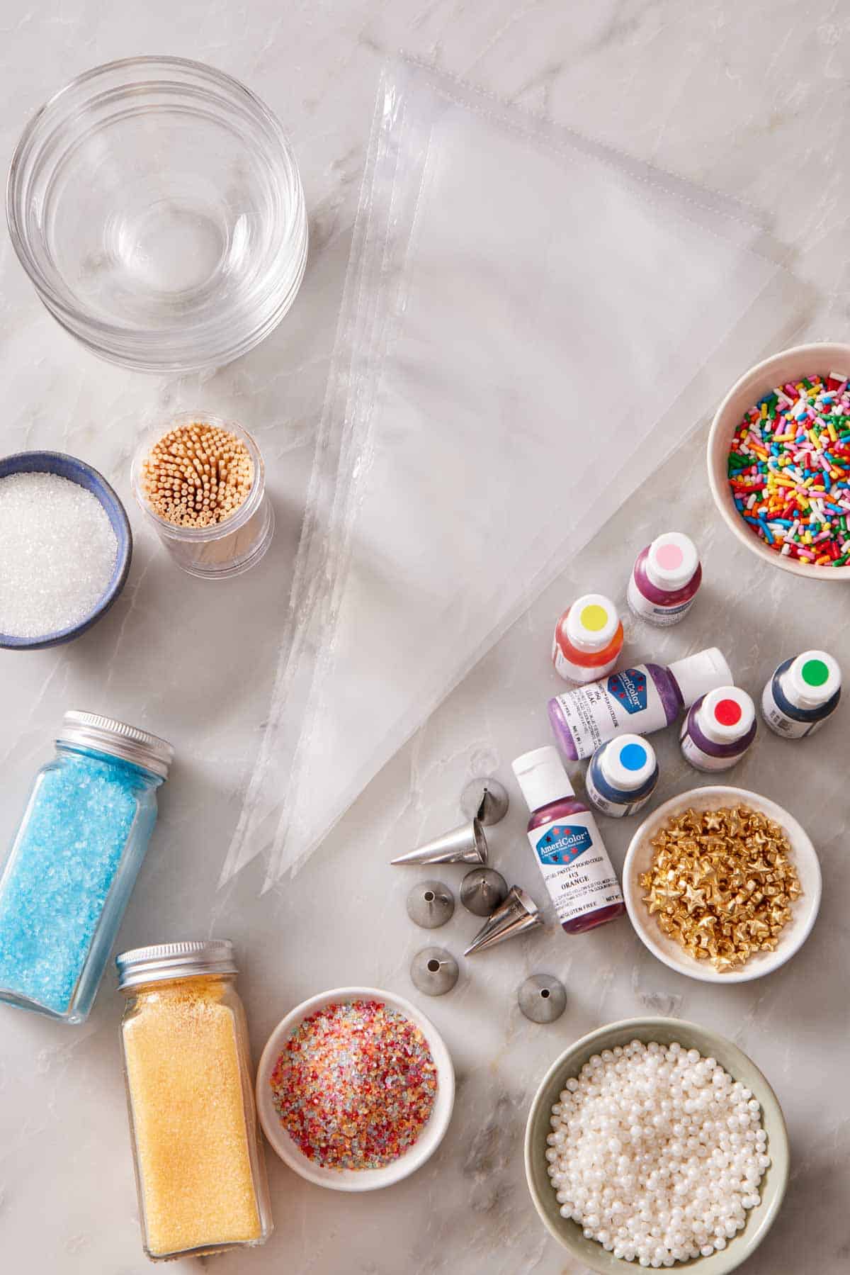 Various cookie decorating tools on a marble countertop.