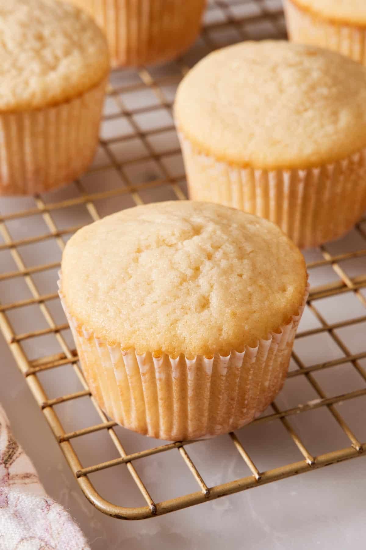 Close-up of unfrosted cupcakes on a wire rack.
