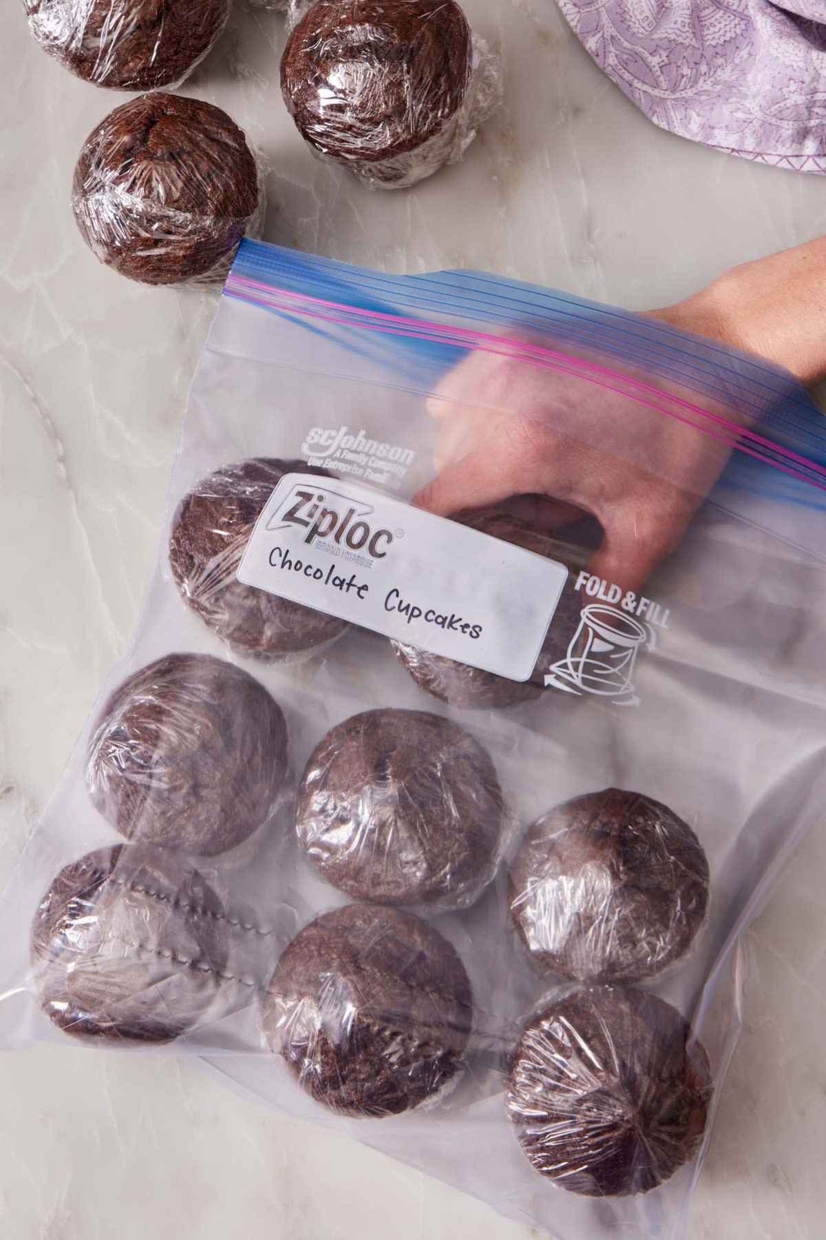 Wrapped chocolate cupcakes placed in a Ziploc bag for freezing.