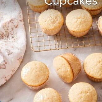 Pinterest graphic showing vanilla cupcakes on a wire rack, as well as a few on a counter wrapped in plastic wrap.