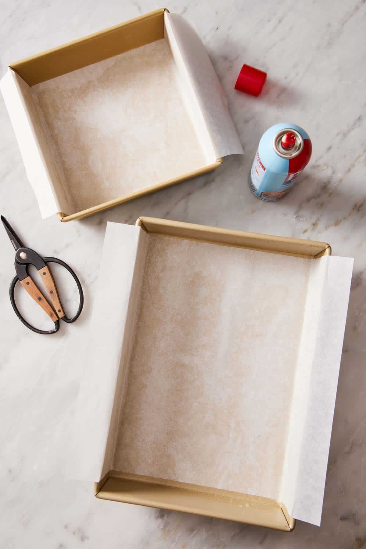 Overhead shot of parchment paper slings in square and rectangular cake pans.