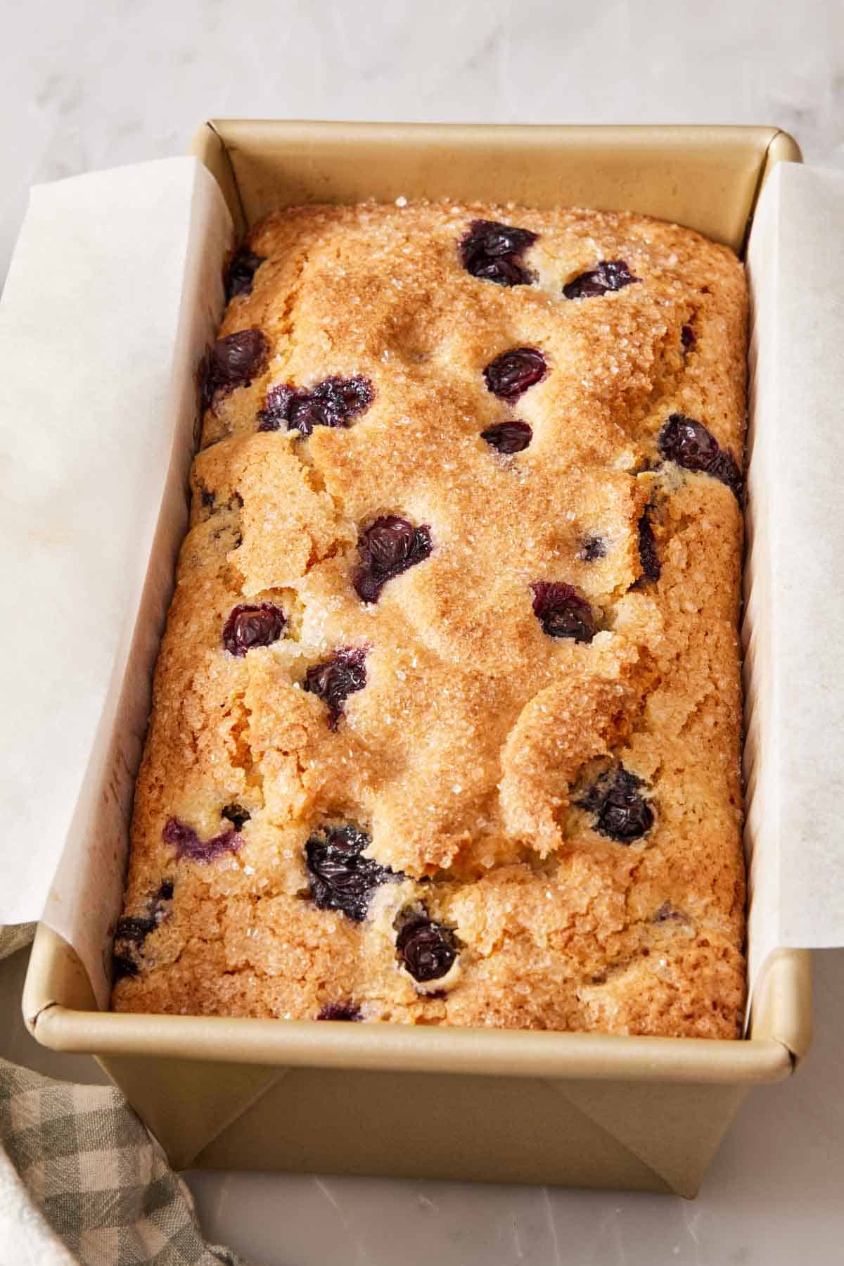 Quick bread in a loaf pan with a parchment sling.