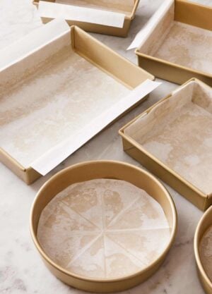 Various cake pans lined with parchment paper.