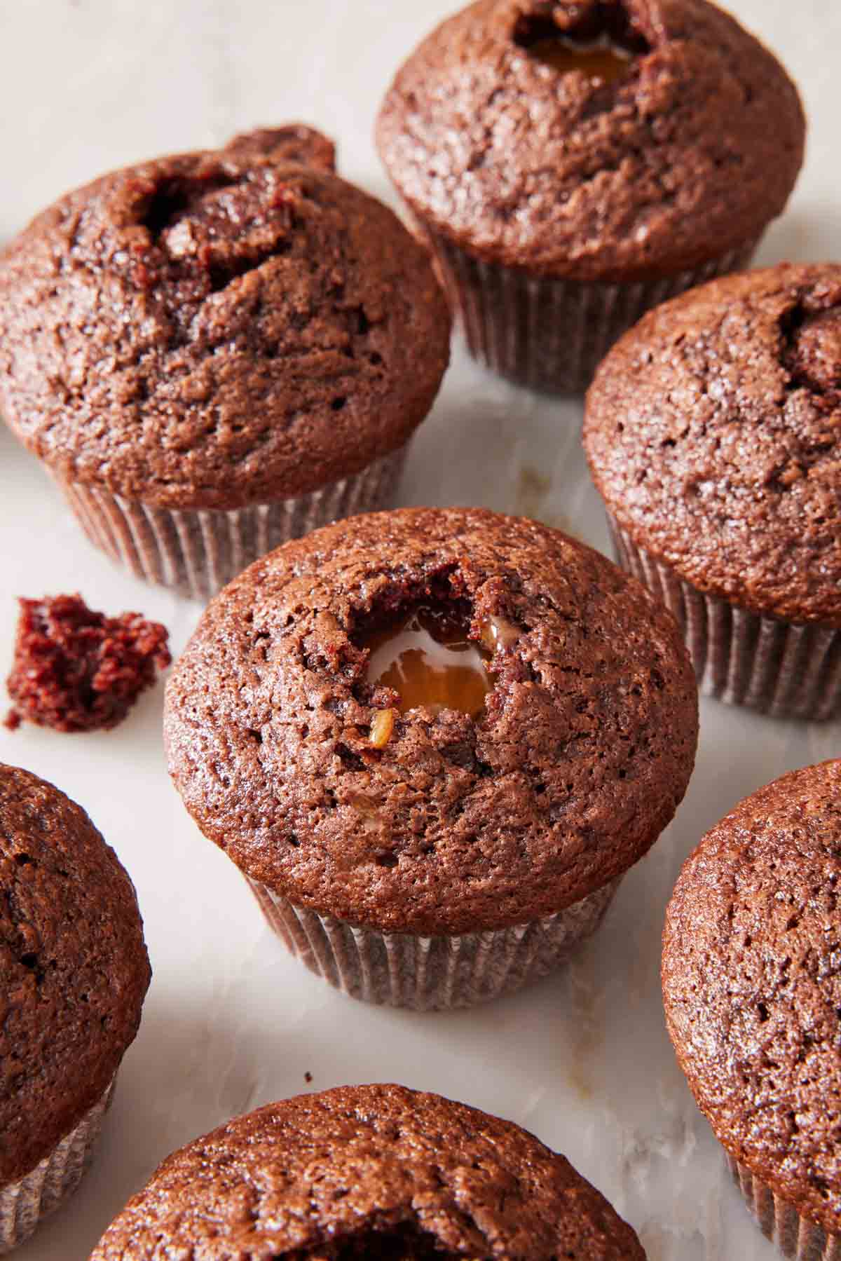 Chocolate cupcakes on a countertop, all filled with caramel.