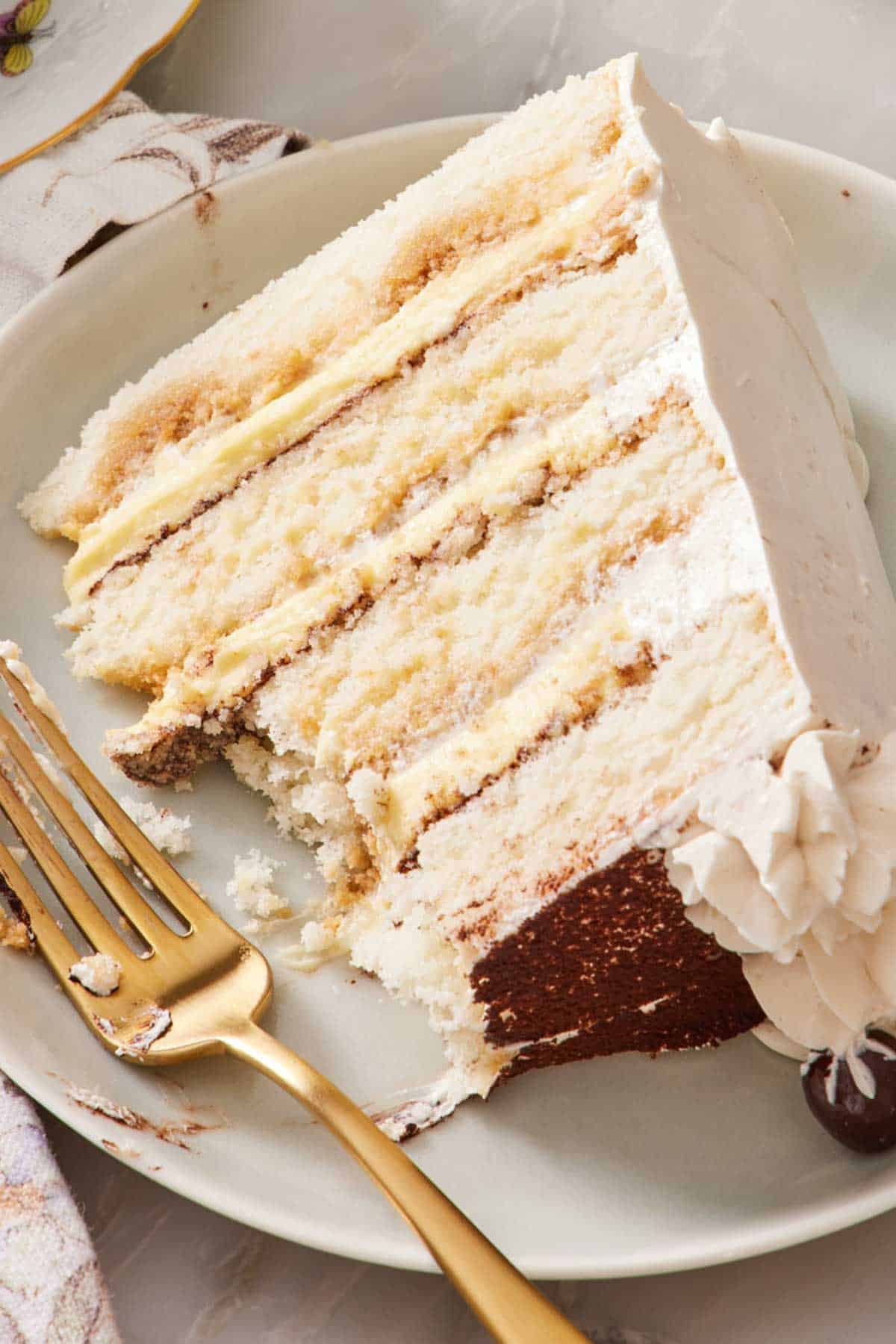 Close-up of a slice of tiramisu cake with a few forkfuls removed.