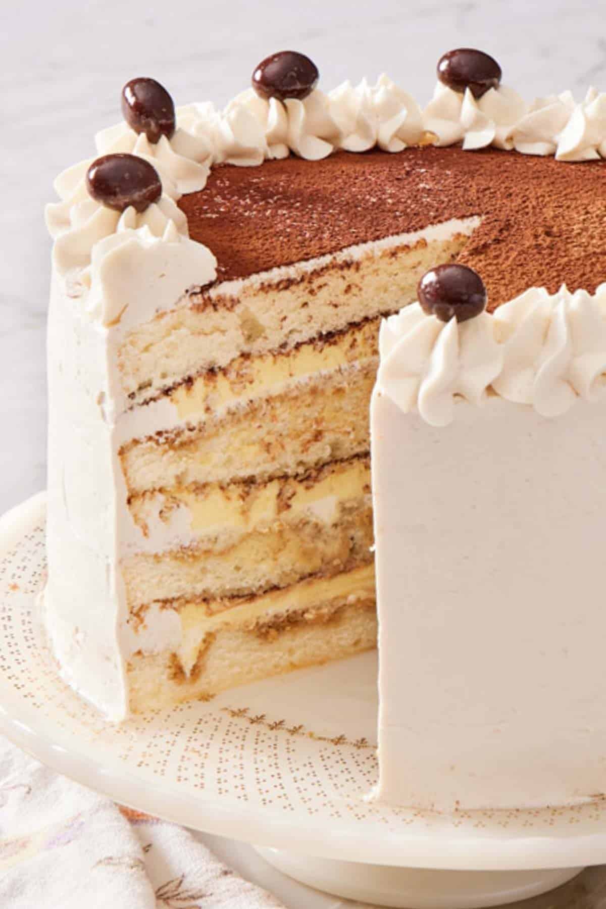 Close-up of tiramisu cake with a slice removed.