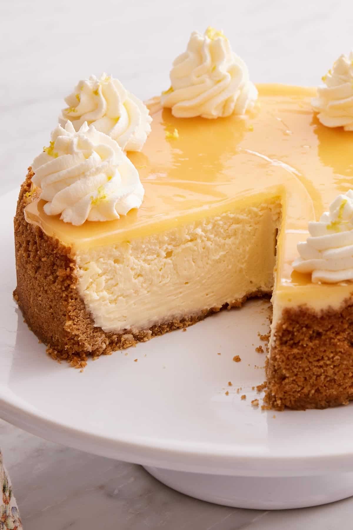 Close-up of lemon cheesecake with a slice removed.