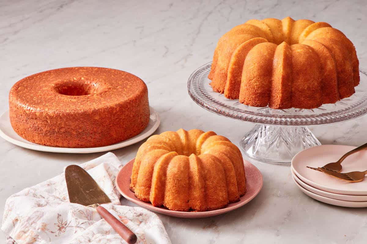 Various Bundt cakes: one on a cake stand, and the other two on plates.