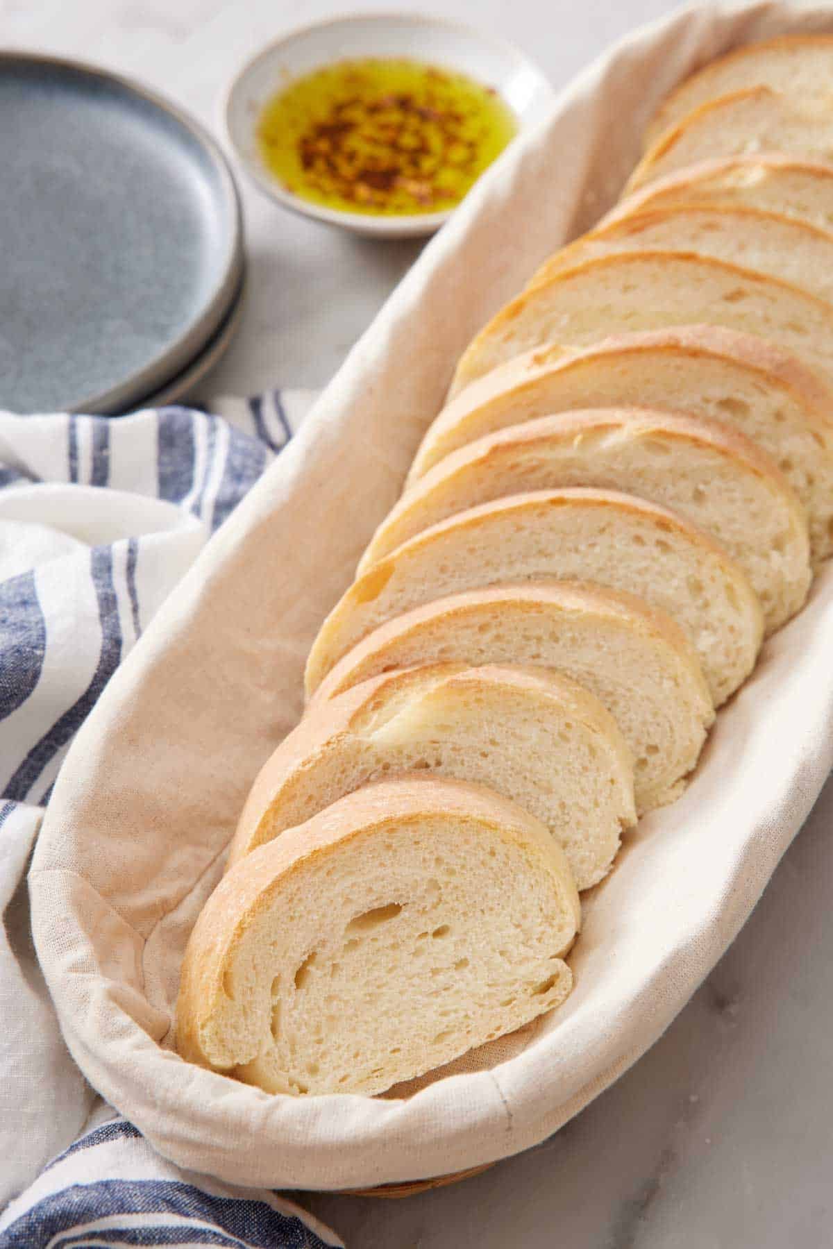 Slices of Italian bread in a long bread basket.