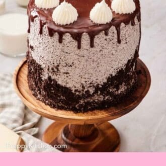 Pinterest graphic showing Oreo cake on a wooden cake stand set on a marble countertop.
