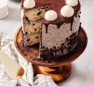 Pinterest graphic showing an angled overhead shot of Oreo cake with a slice cut out and on a plate mostly out of frame in the background.