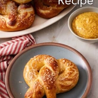 Pinterest graphic showing a soft pretzel on a plate with a dipping sauce and a pile of pretzels behind it.